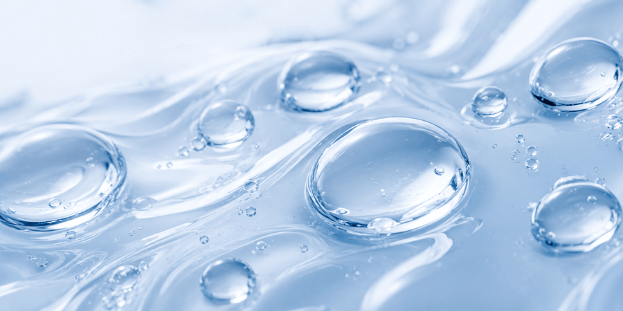 Water droplets on a translucent gel representing sodium hyaluronate and hydration.